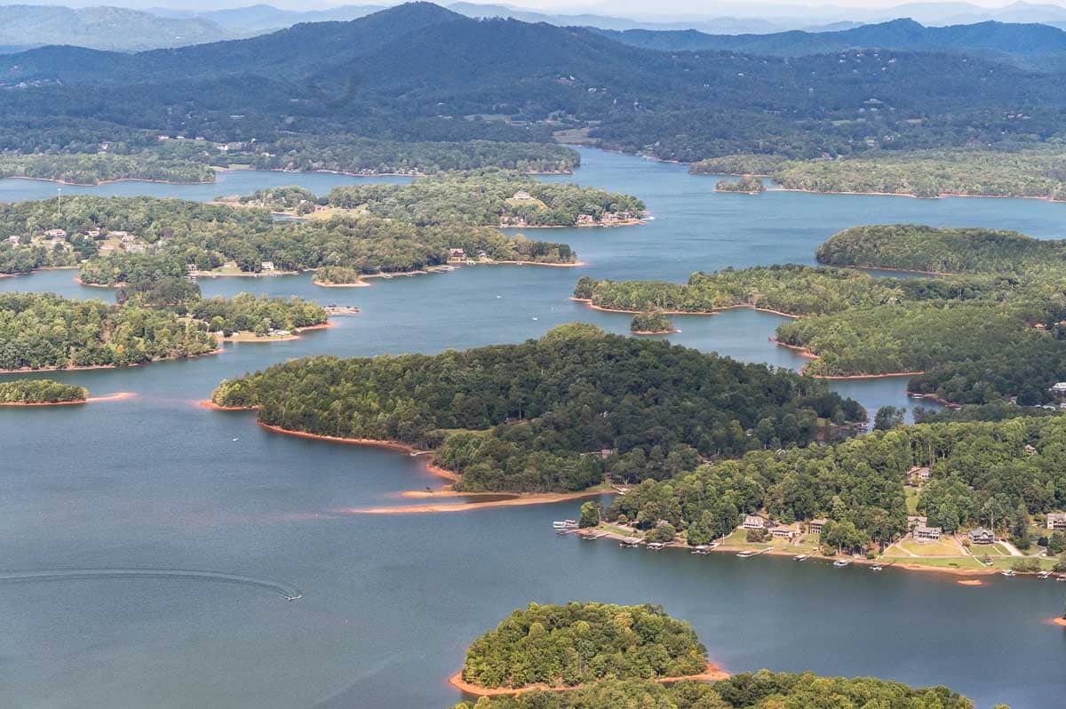 Lake Chatuge shoreline with waterfront homes surrounded by the Blue Ridge Mountains in Western North Carolina and North Georgia.
