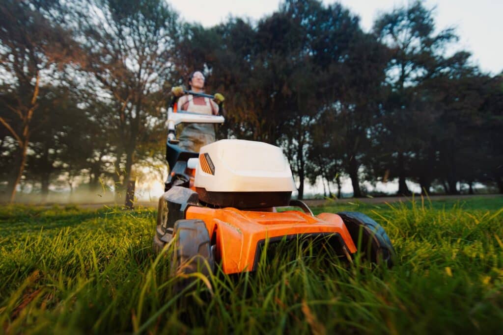 Battery-powered STIHL lawn mower being used during summer maintenance at a mountain home.